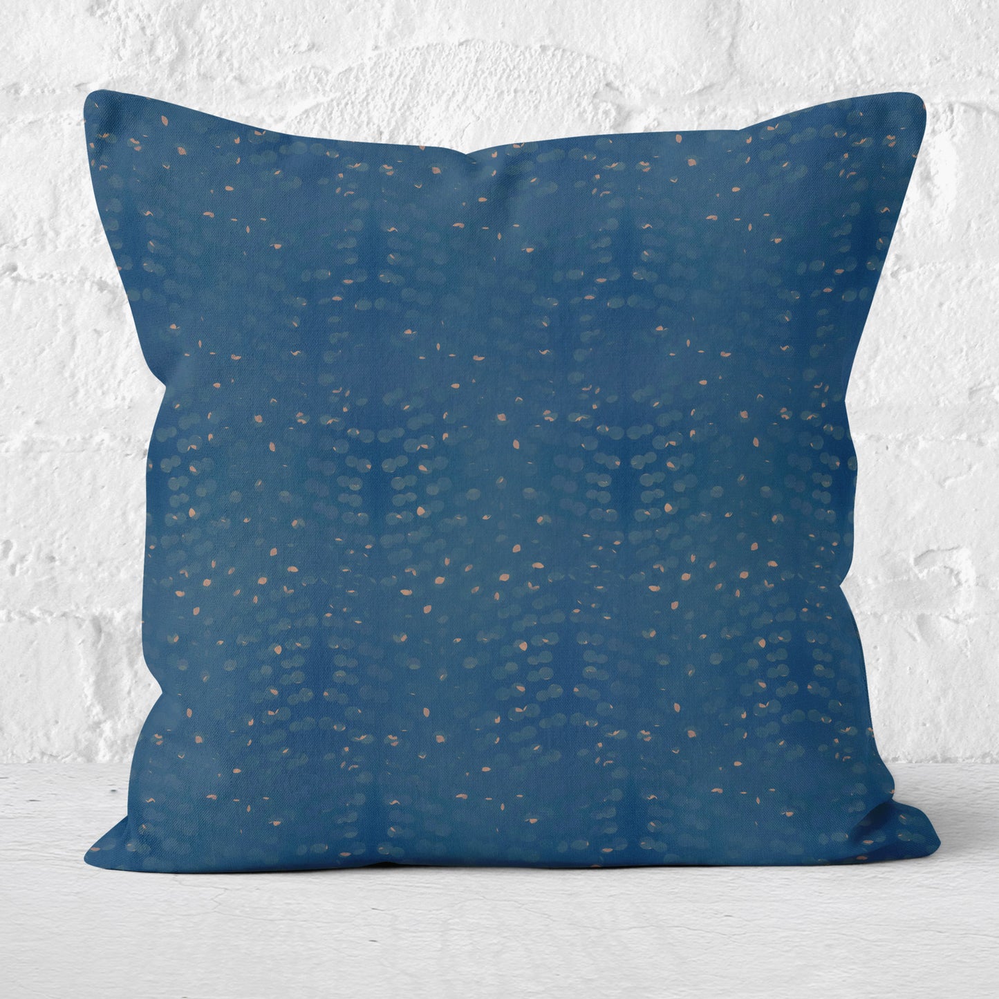 Square throw pillow featuring abstract hand painted pattern in blue and tan