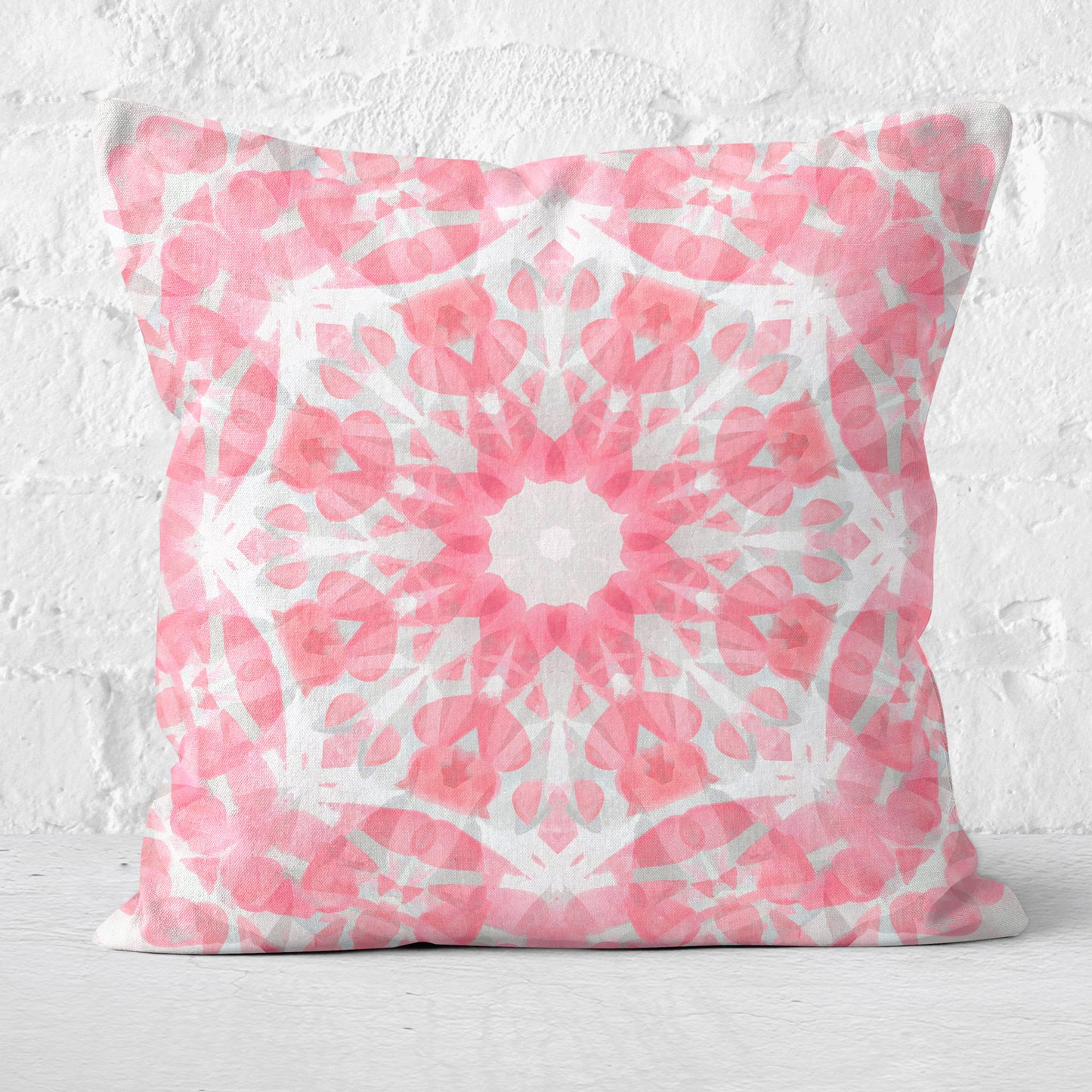 Square throw pillow featuring a pink mandala design set against a white brick background