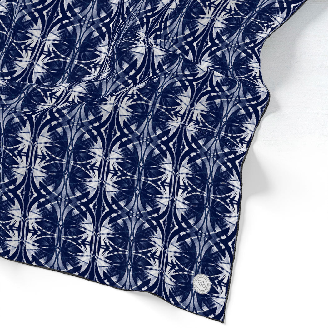 Silk scarf featuring a navy blue and white hand-painted pattern.