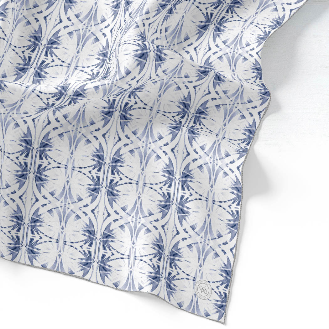 Silk scarf featuring a hand-painted blue and white pattern.