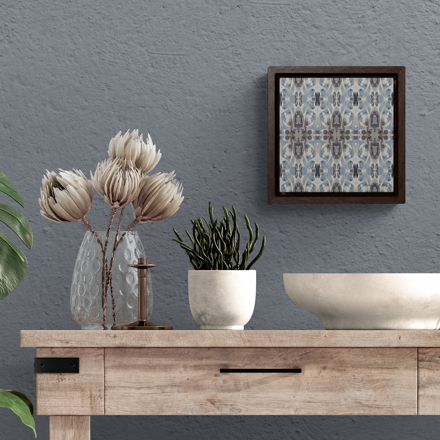 Framed mini canvas print hanging above a console and various vases