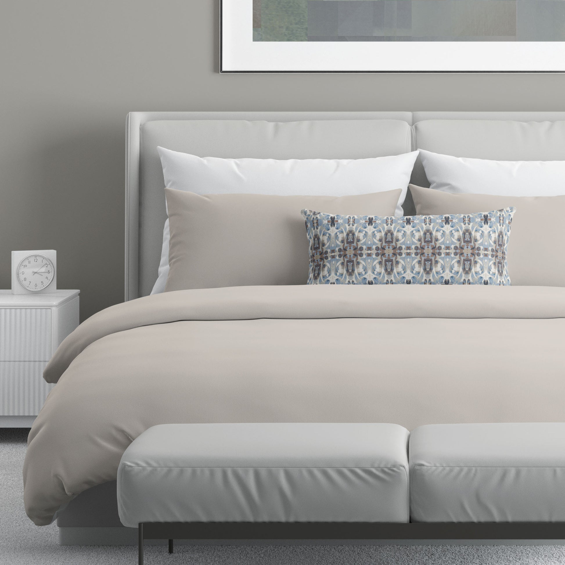 Neutral colored bedroom featuring a bed with an abstract patterned lumbar pillow.