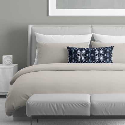 Neutral colored bedroom featuring a blue and white lumbar pillow