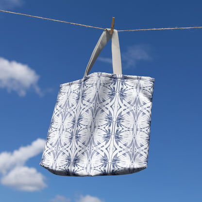 Oversized canvas tote hanging from a clothesline, featuring a blue and white abstract pattern