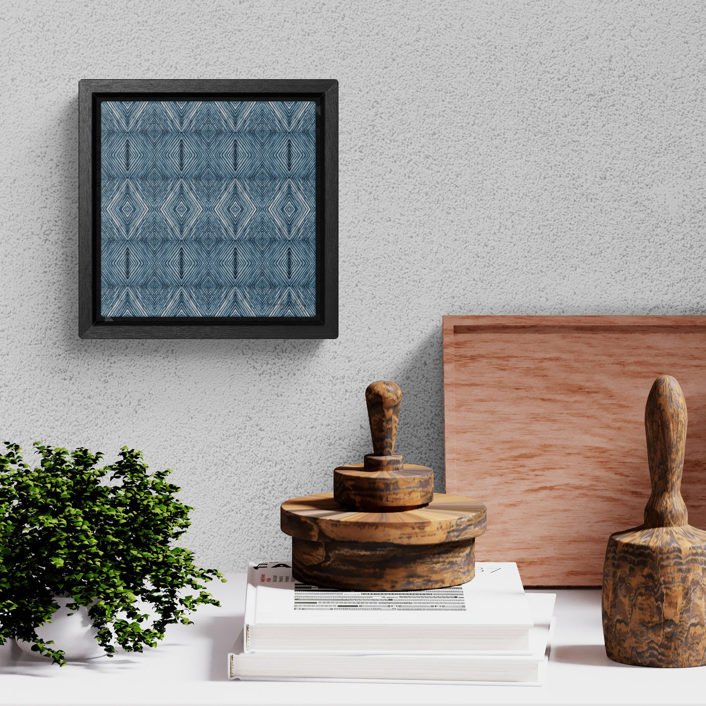 Framed Mini Canvas Print featuring a blue abstract diamond pattern, hanging above artist workroom tools.