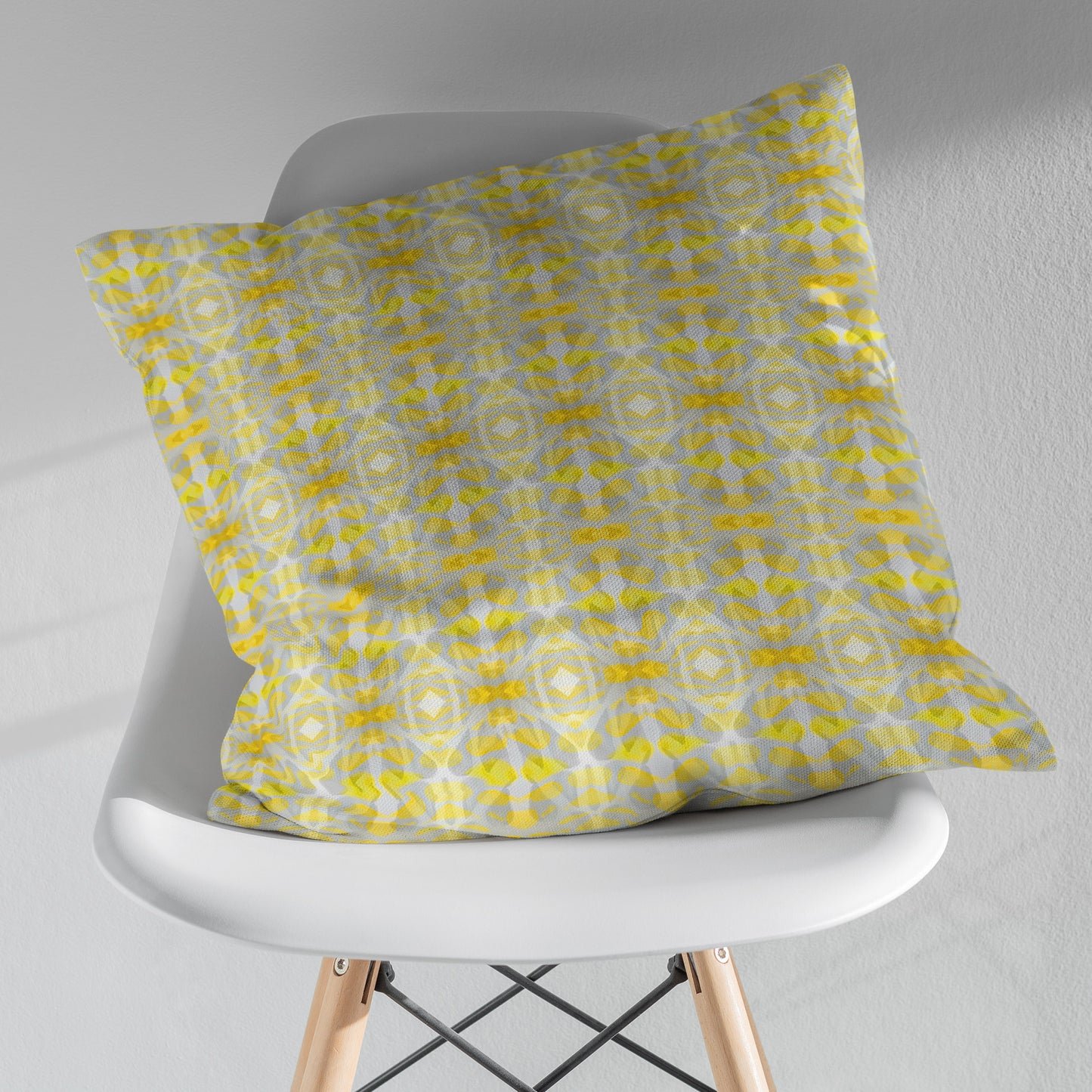 Yellow patterned pillow sitting on a white modernist chair