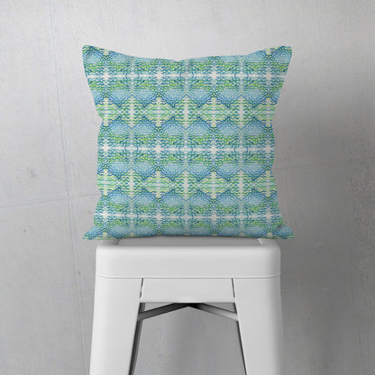 Throw pillow featuring a blue and green abstract, hand-painted watercolor pattern., sitting on a white metal stool