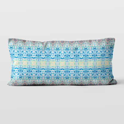 Rectangular lumbar pillow featuring a handpainted pattern in blue, pink, and yellow.