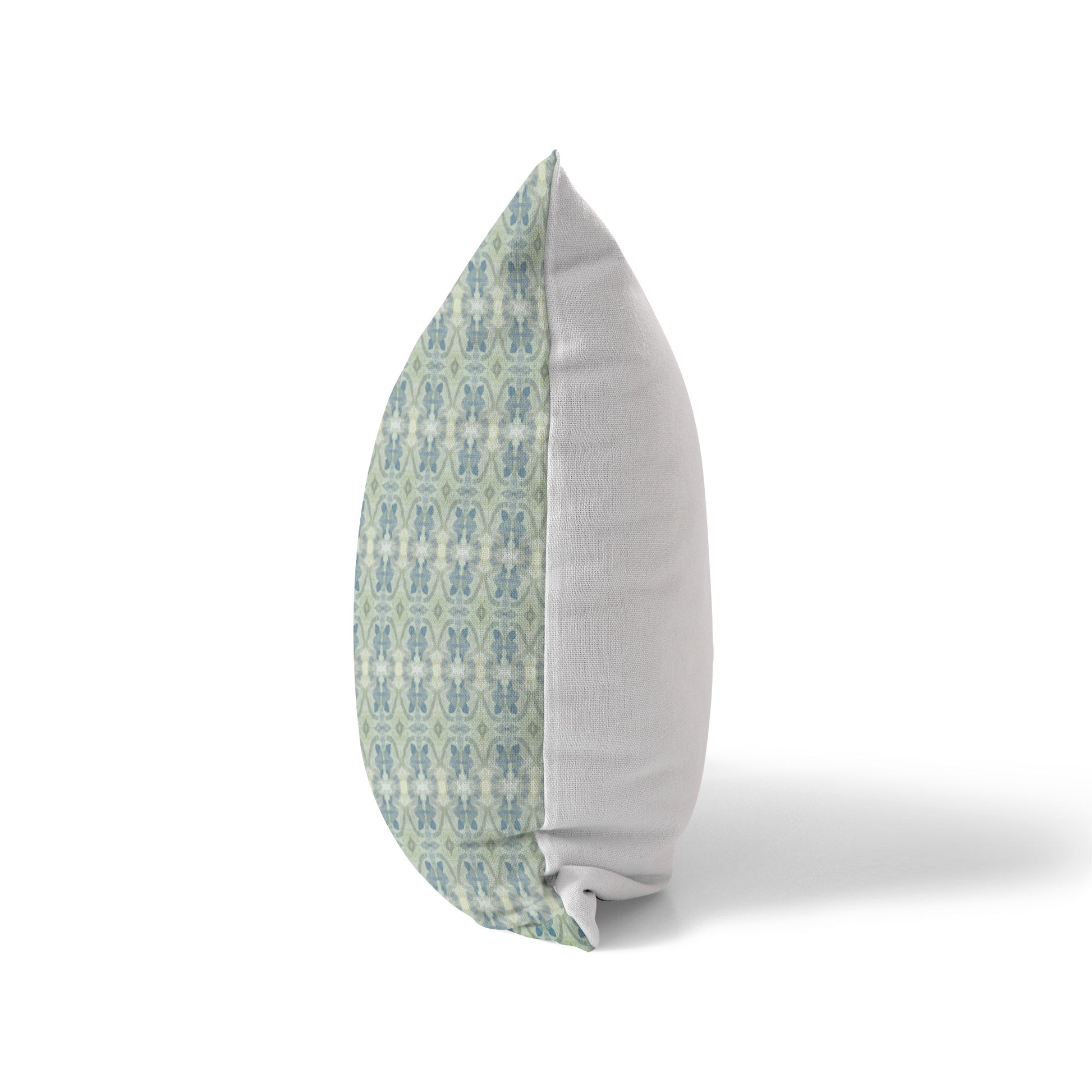 Side view of a pillow featuring a green and blue abstract floral pattern and a solid white back