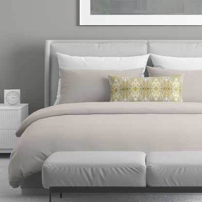 Neutral colored bedroom featuring a bed with a gold and gray abstract patterned lumbar pillow.