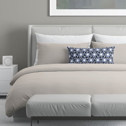 Neutral colored bedroom featuring a bed with a blue and white abstract patterned lumbar pillow.
