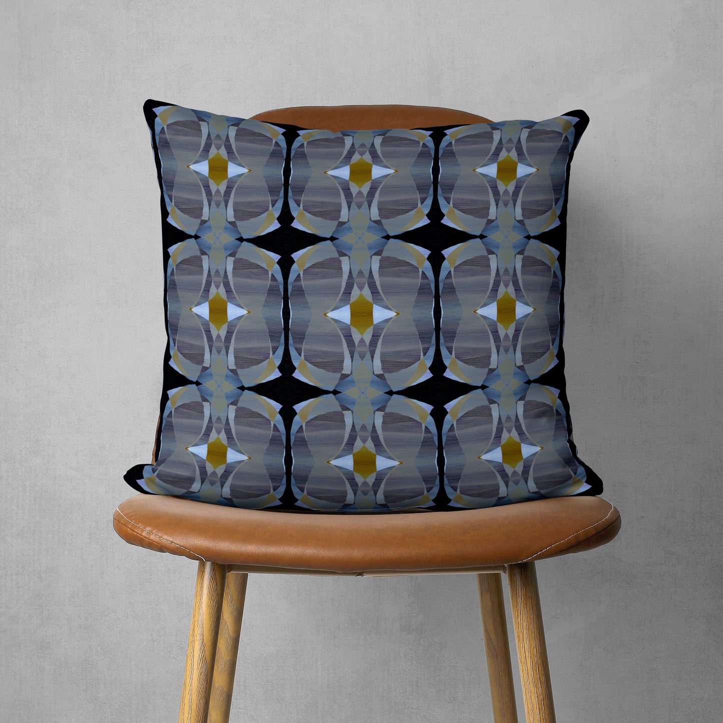 Gray and black abstract patterned pillow sitting on a brown chair