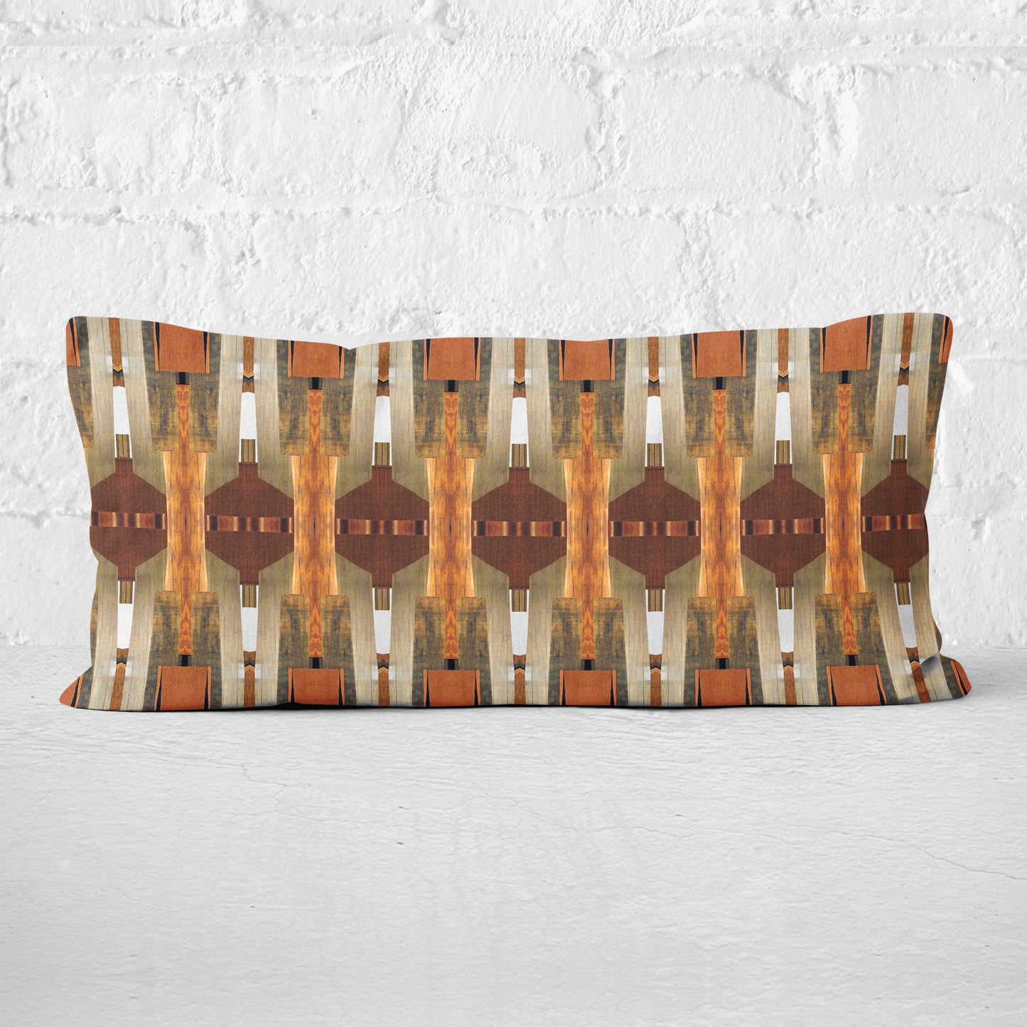 12 x 24 pillow featuring a brown paper collage pattern leaning against a white brick wall.