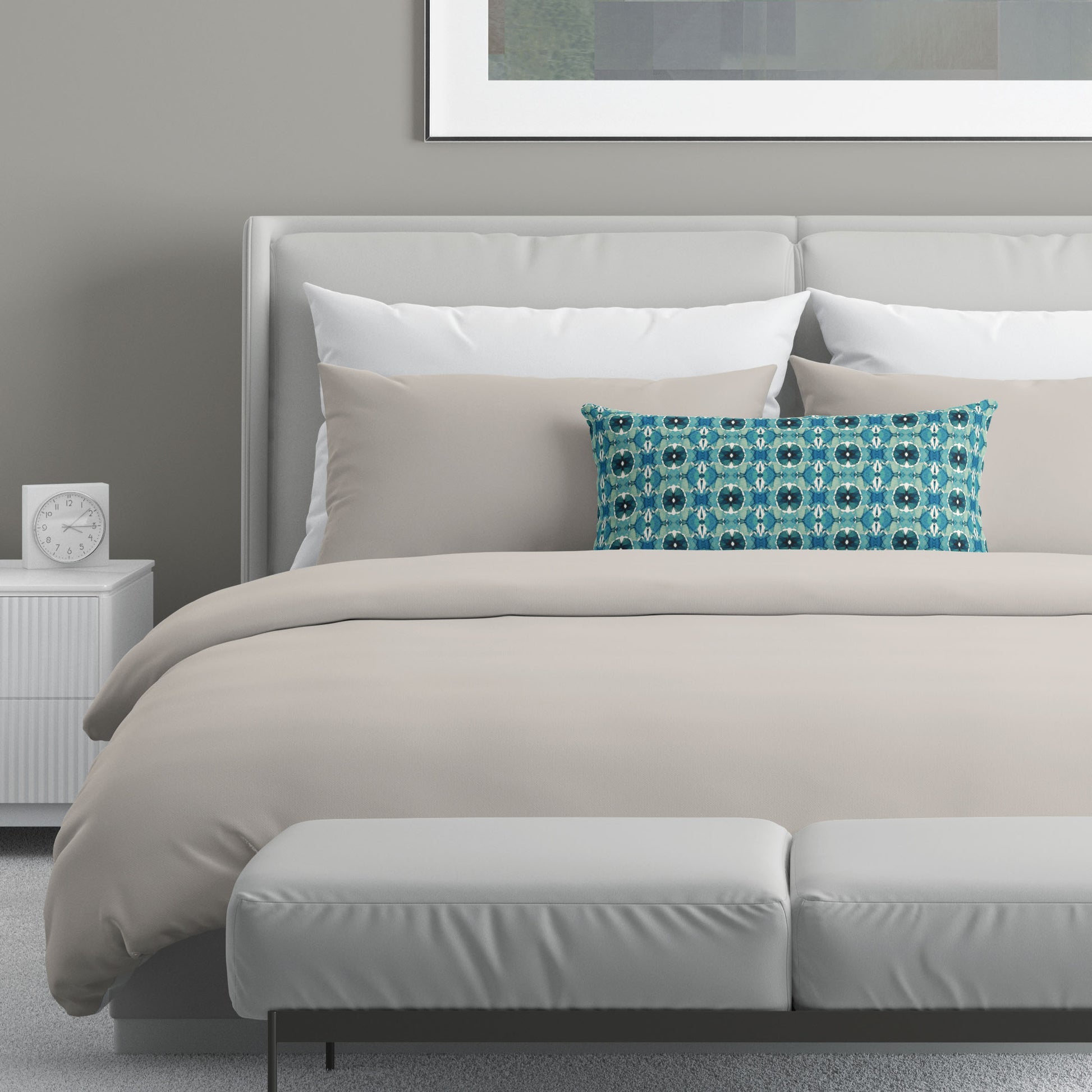 Neutral colored bedroom featuring a bed with a teal abstract patterned lumbar pillow.