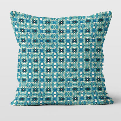 Throw pillow featuring hand-painted geometric pattern in teal.