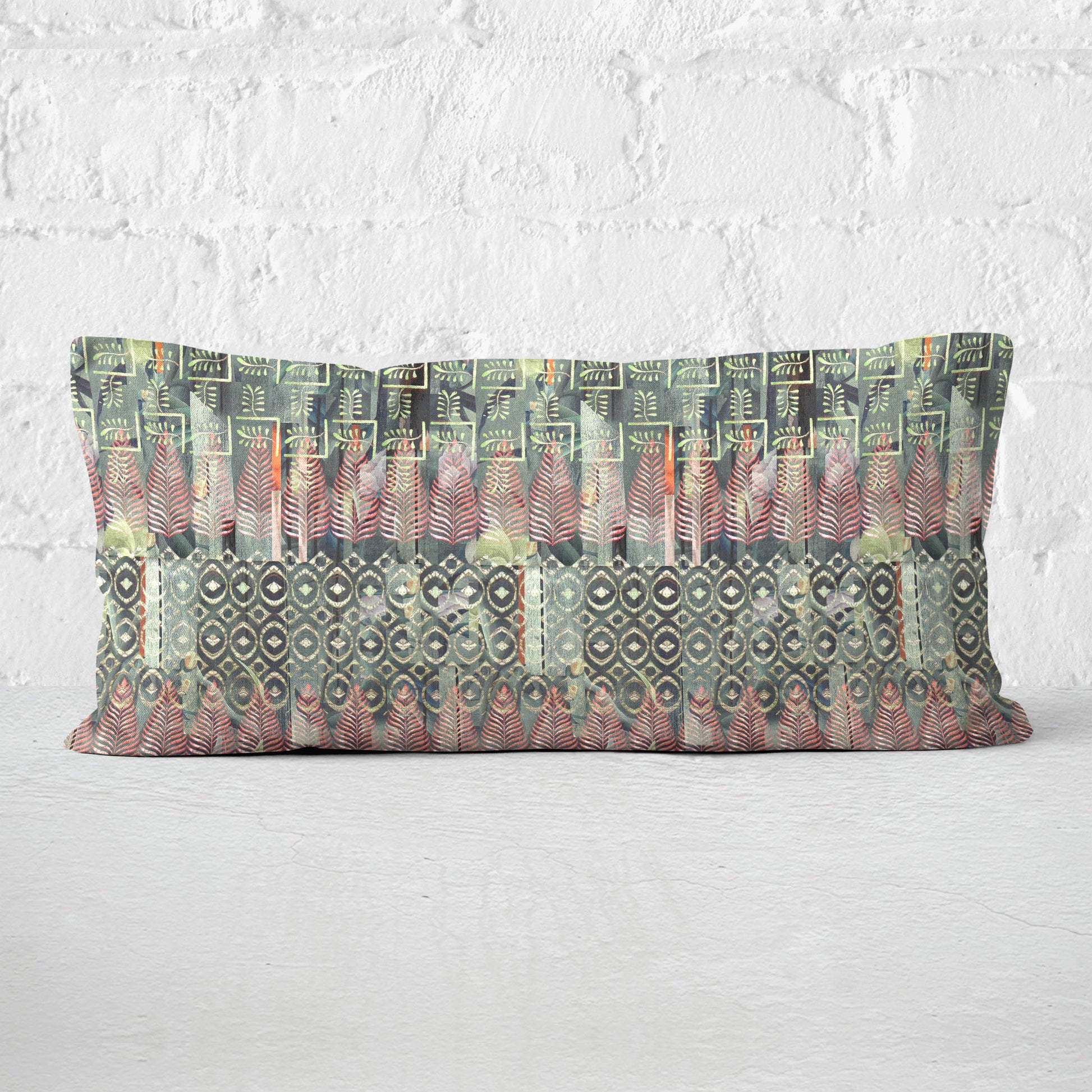 Rectangular lumbar pillow featuring a collaged and block print pattern in green set against a white brick wall.