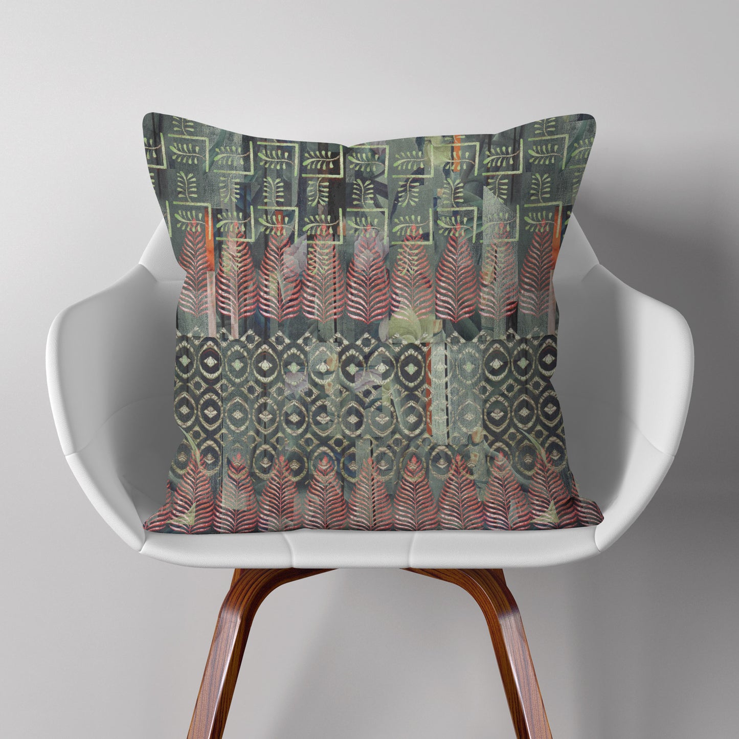 Square throw pillow featuring a green and red Indian block print pattern, sitting on a modern white chair