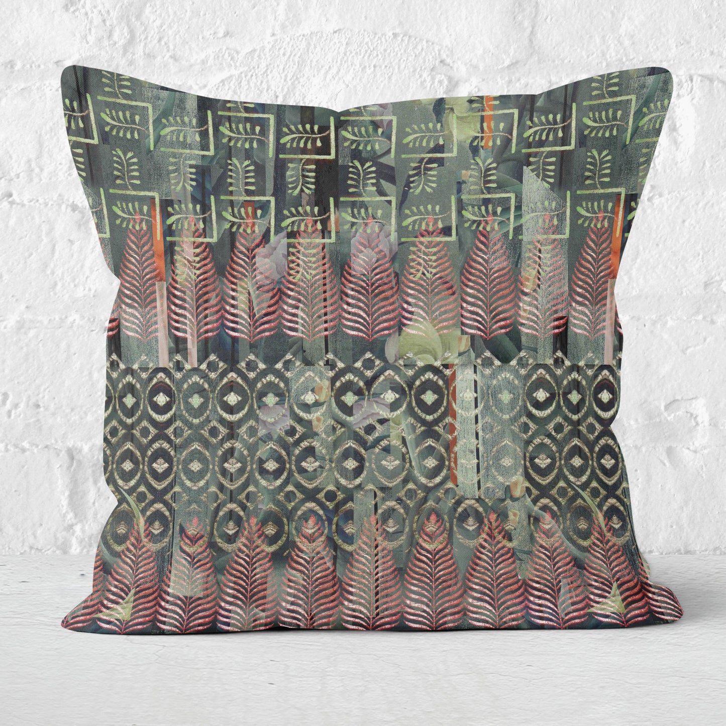 Square throw pillow featuring a green and red Indian block print pattern, set in front of a white brick wall