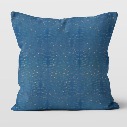 Square throw pillow featuring abstract hand painted pattern in blue and tan
