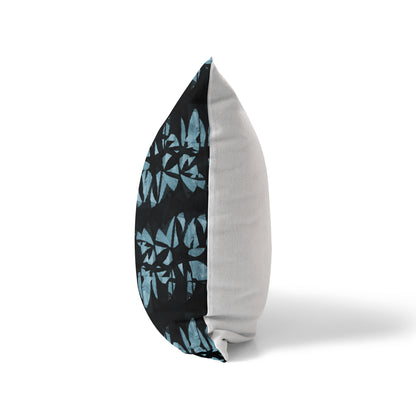 Side view of a pillow featuring an abstract black and teal pattern and solid white back