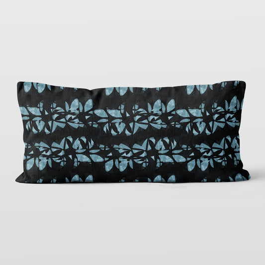 Lumbar pillow featuring an abstract black and aqua floral lei pattern