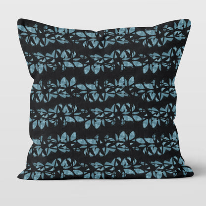 Square throw pillow featuring hand painted, abstract floral lei pattern in aqua blue and black.