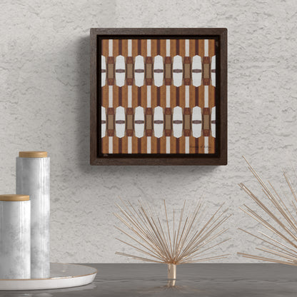 Stretched canvas featuring a brown and white abstract pattern in a brown float frame, hanging above a table with decorative objects
