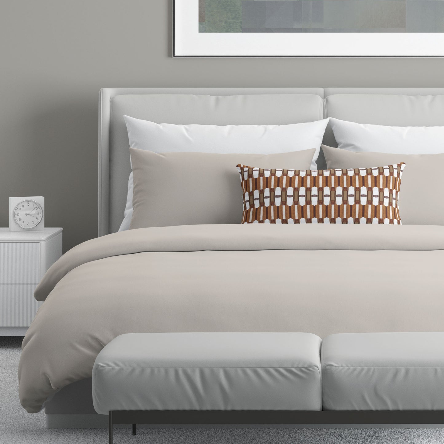 Neutral colored bedroom featuring a bed with a brown and white abstract patterned lumbar pillow.
