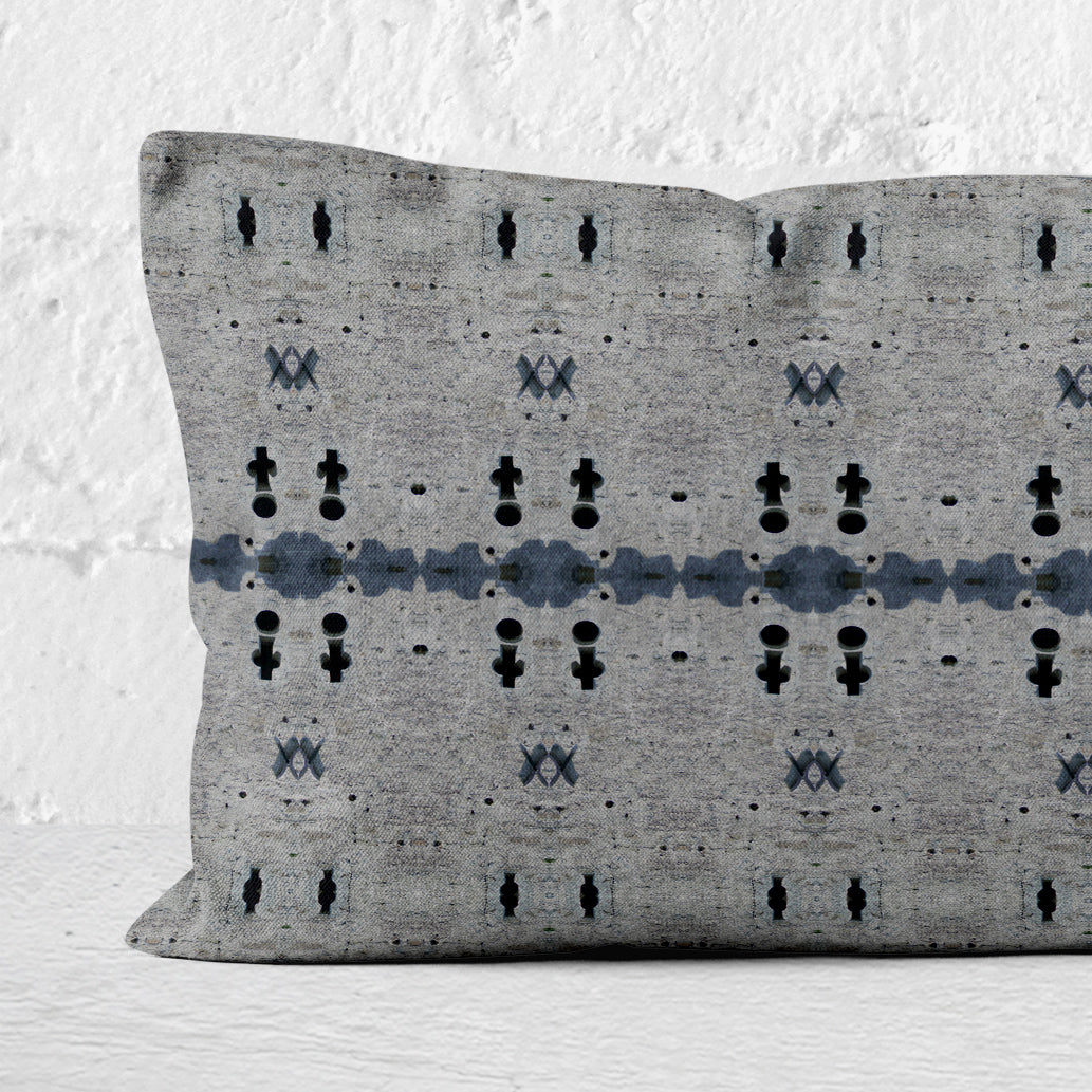 Close up of a 12x24 rectangular lumbar pillow featuring an abstract gray and dark blue pattern