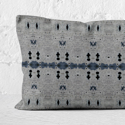 Close up of a 12x24 rectangular lumbar pillow featuring an abstract gray and dark blue pattern