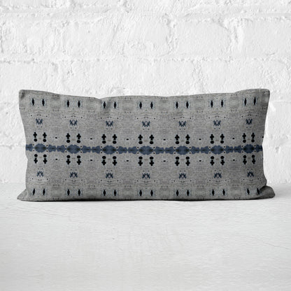 12x24 rectangular lumbar pillow featuring an abstract gray and dark blue pattern, set against a white wall