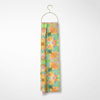 Silk scarf featuring an abstract peach and green hand-painted pattern