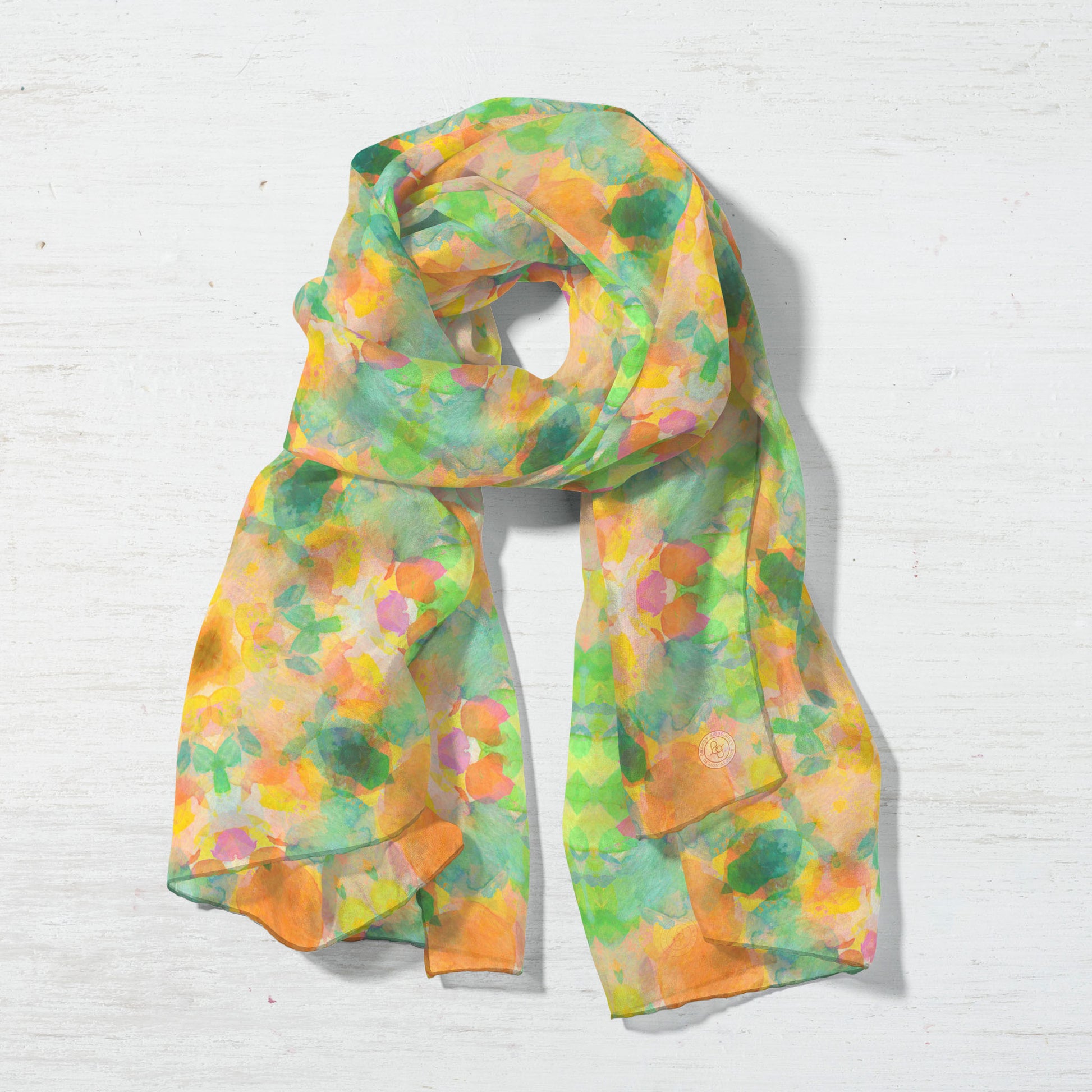 Silk scarf featuring an abstract peach and green hand-painted pattern