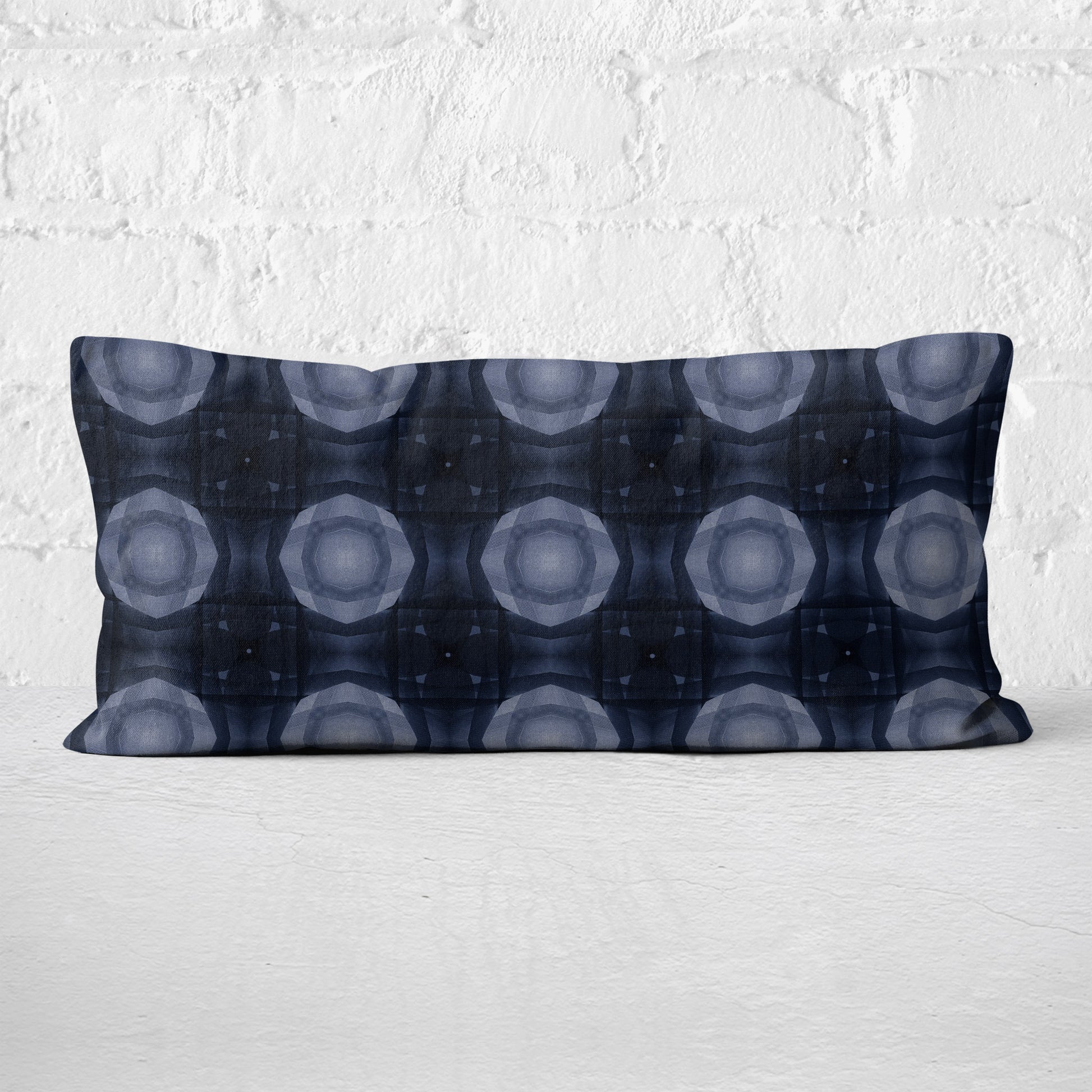 Lumbar pillow featuring a collage-based geometric pattern in shades of blue against a white brick background.