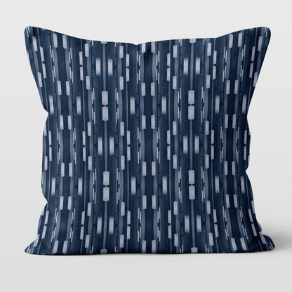Pillow featuring collaged stripe pattern in blue and white