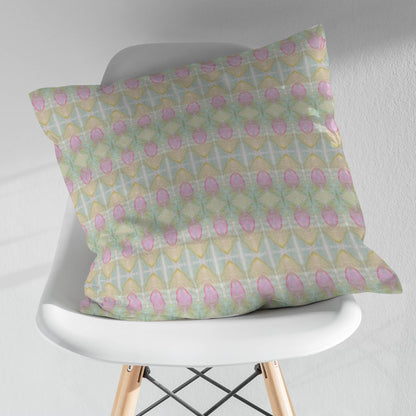 Square throw pillow featuring a pastel rosebud pattern in pink, green, blue, and peach, sitting on a modern white chair.