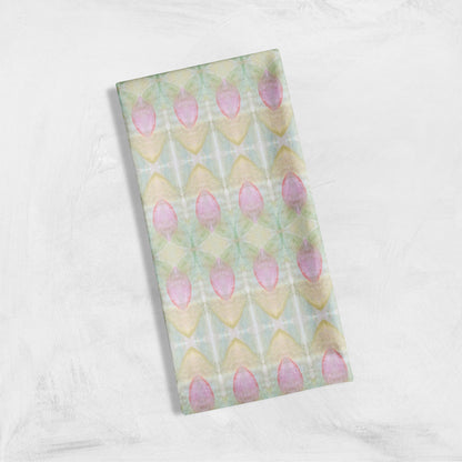 Folded tea towel featuring an abstract pink floral pattern