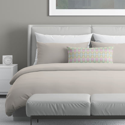 Neutral colored bedroom featuring a bed with a pastel multicolored abstract patterned lumbar pillow.
