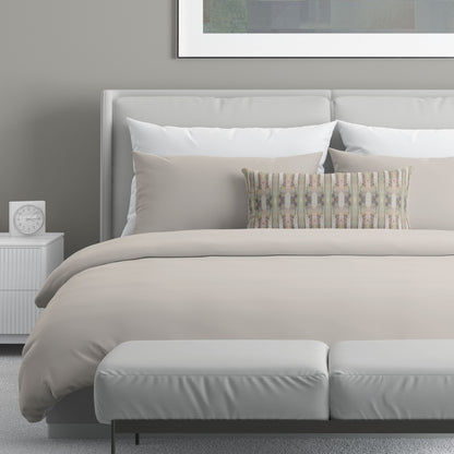 Neutral bedroom featuring a 12 x 24 pillow with a pink, green, and beige cut paper collage pattern