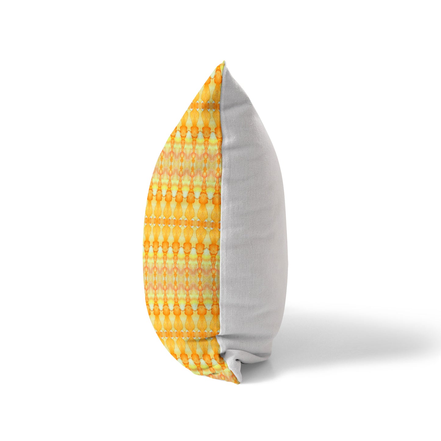 Side view of a pillow featuring a yellow and orange pattern and solid white back
