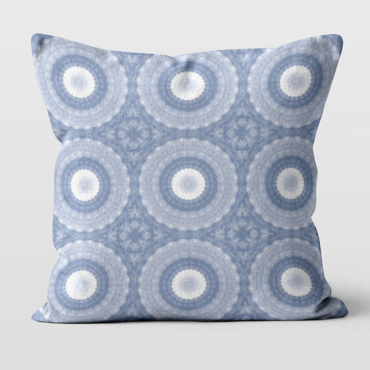 Square throw pillow featuring a periwinkle blue, purple, and white abstract circular pattern