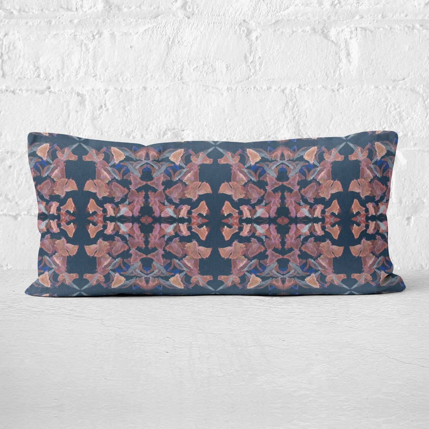 12x24 pillow featuring a hand-painted mauve and gray abstract pattern leaning against a white brick wall.