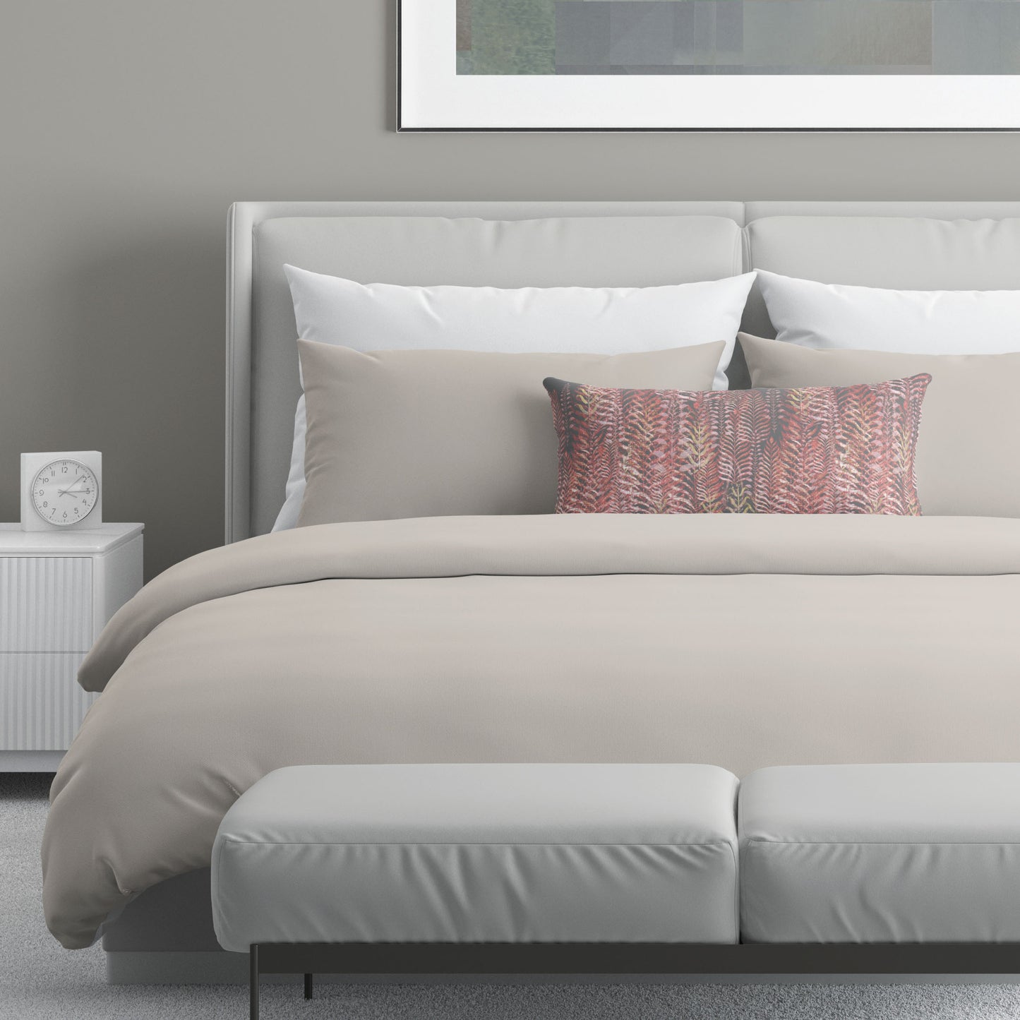 12 x 24 inch lumbar pillow featuring feather block print in pink and gray tones on top of neutral bed linens.