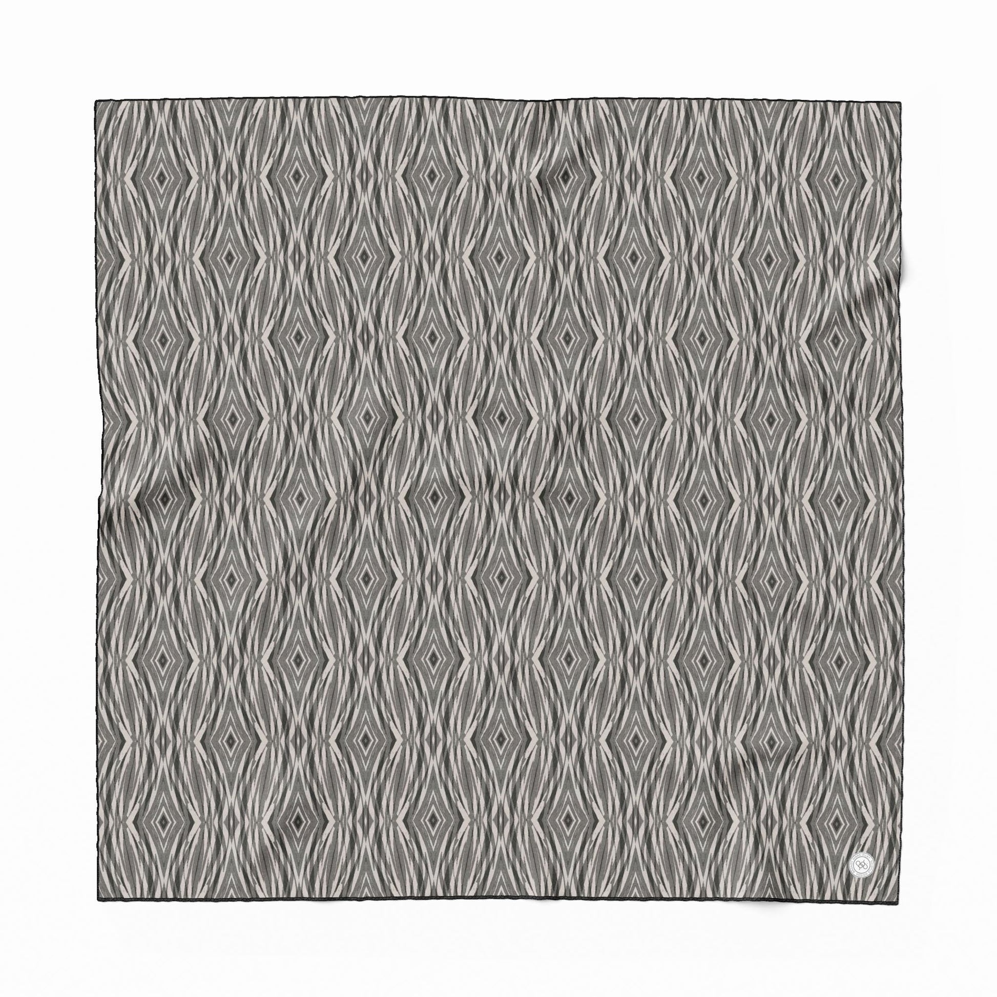 Ssilk scarf featuring a linocut pattern in beige, gray, and black.