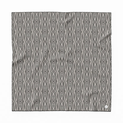Ssilk scarf featuring a linocut pattern in beige, gray, and black.