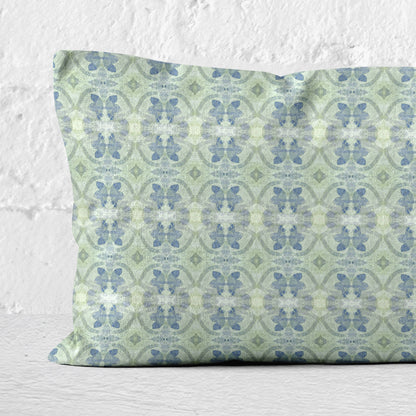 Detail of a lumbar pillow featuring a hand-painted green and blue abstract pattern