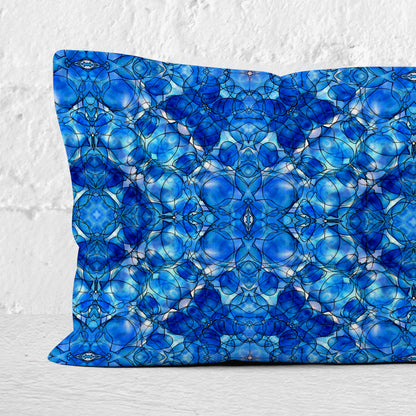 Detail of a rectangular lumbar pillow featuring a hand painted abstract pattern in cobalt blue.