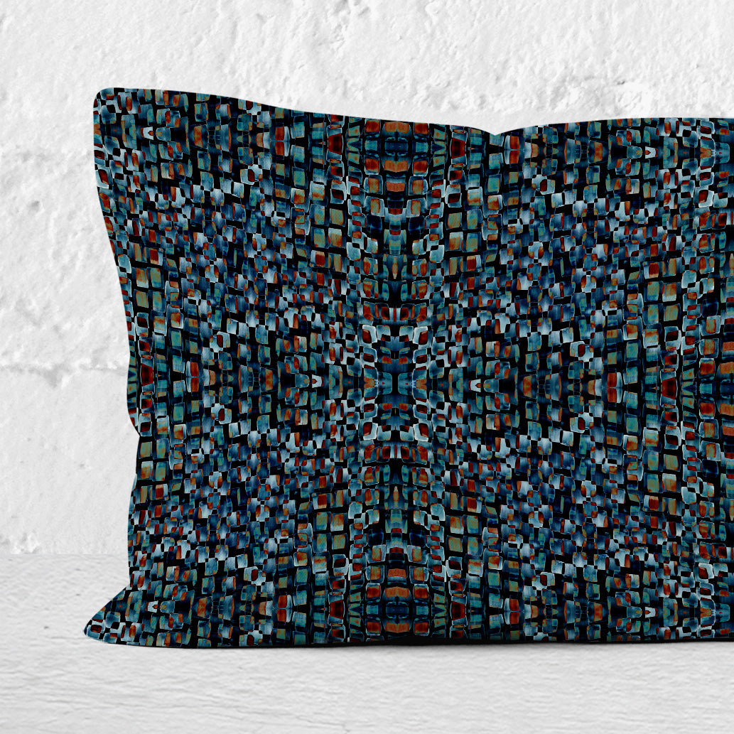 Detail of a rectangular lumbar pillow featuring an abstract hand-painted pattern in black, dark blue, and brown.