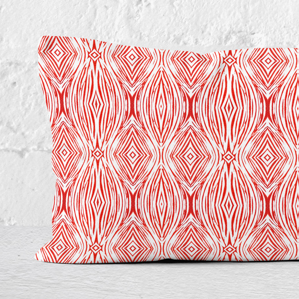 Detail of a 12 x 24 lumbar pillow featuring a red and white abstract linocut pattern.