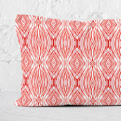 Detail of a 12 x 24 lumbar pillow featuring a red and white abstract linocut pattern.